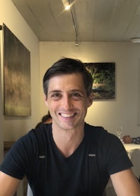 a man smiling at a table in a restaurant